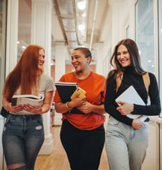 Three students walking down hallway